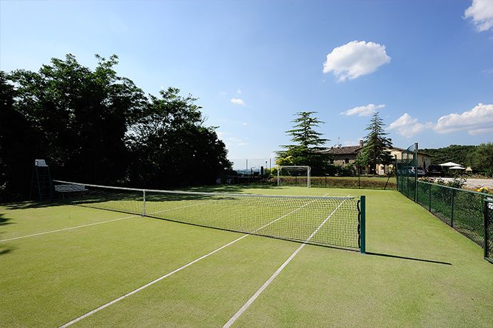 Ein Tennisplatz, umgeben von Bäumen in einem grünen Gebiet.