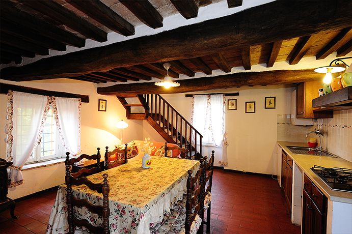 Eine einfach gestaltete Küche mit rustikalen Elementen und einem Tisch, der für eine Mahlzeit gedeckt ist.