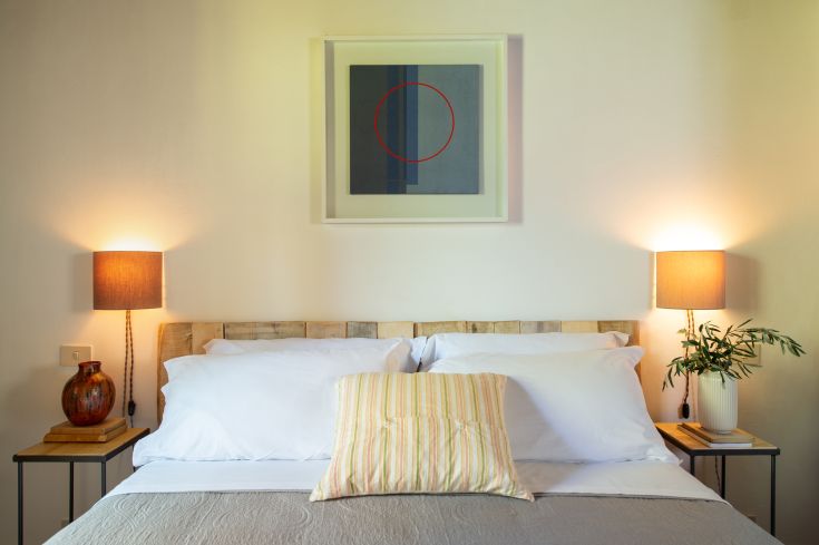 Chambre matrimoniale simple avec des éléments de décoration modernes et une lumière douce.