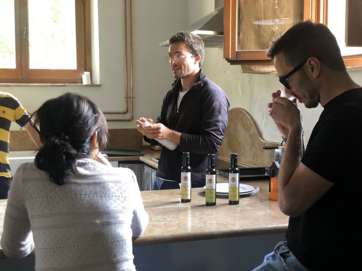 Un moment de dégustation de produits locaux dans une ferme, avec des ustensiles de cuisine et des bouteilles d'huile disposés sur la table.