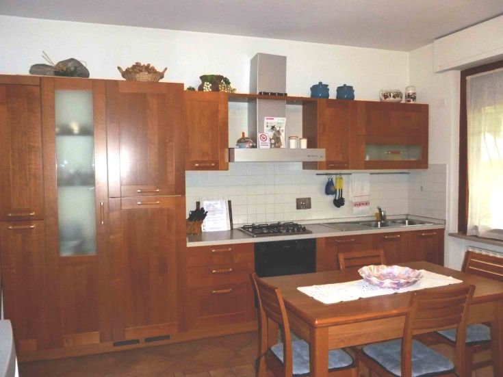 Cucina in legno calda e pratica, completa di tavolo e spazio per il soggiorno.