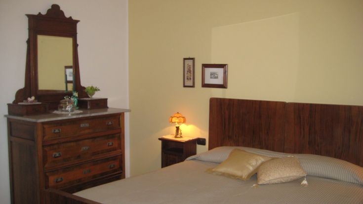 Camera semplice con arredi in legno e decorazioni sobrie, perfetta per un soggiorno confortevole.