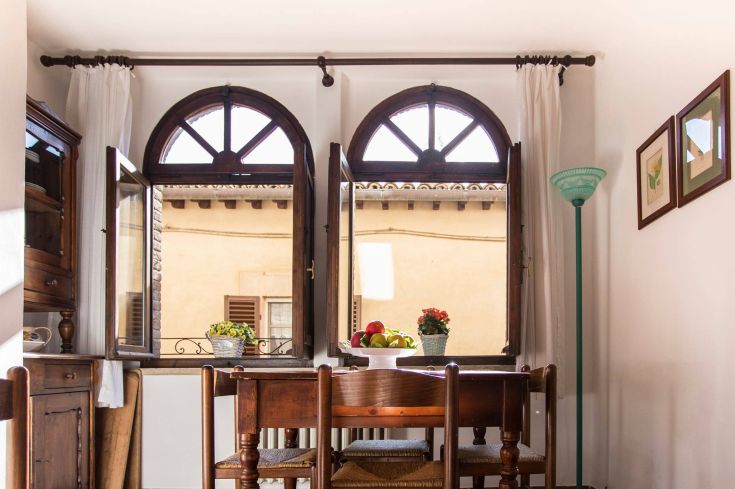 A cozy kitchen with windows overlooking a beautiful landscape.