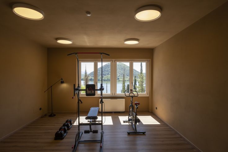 Helle Turnhalle mit Seeblick, ausgestattet mit modernen Geräten und einer komfortablen Atmosphäre.