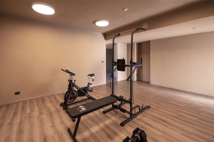 Ein heller und einfacher Fitnessraum mit Fitnessgeräten.