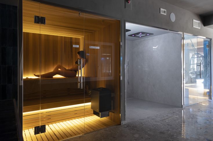 Ein einfacher Wellnessbereich mit Sauna und Duschen, ideal für entspannende Momente.