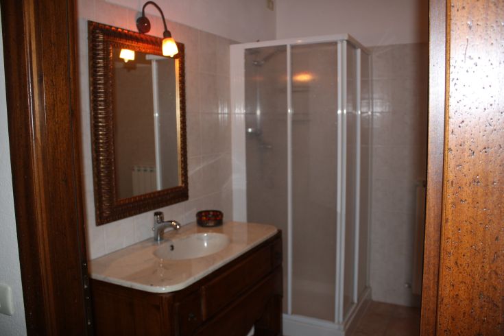Bagno in agriturismo, dotato di doccia, lavabo e specchio, semplice e funzionale.