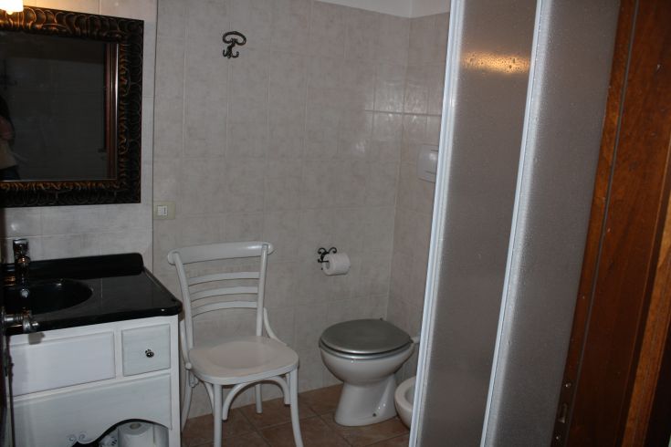 Un bagno semplice e funzionale con lavabo, specchio e doccia.