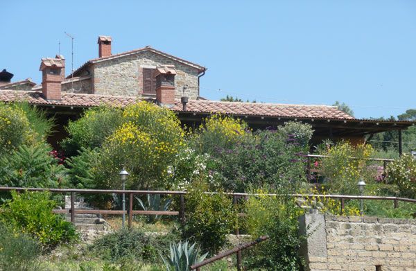 Un agriturismo accogliente immerso nel verde, con un giardino fiorito e un panorama suggestivo.