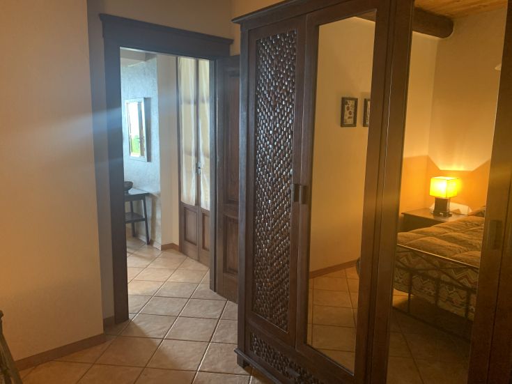 Interni di un appartamento arredato, con armadio e luce naturale che illumina la camera.