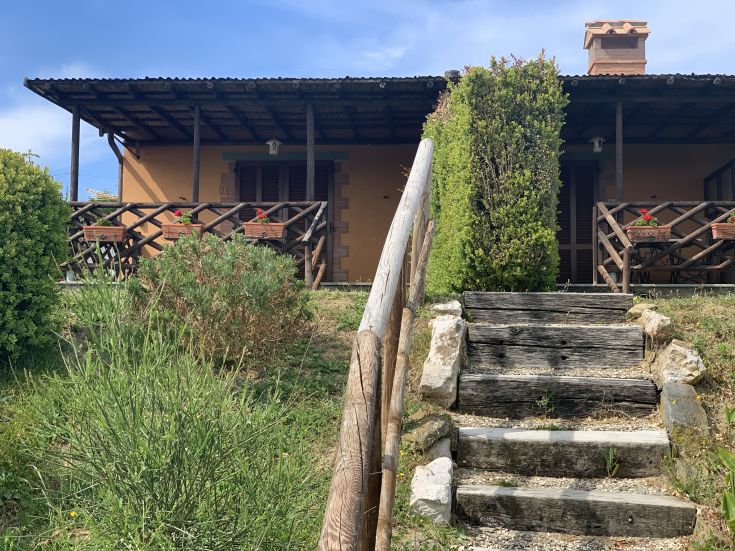 Un agriturismo confortevole circondato da natura, che offre una scena sul Lago Trasimeno.