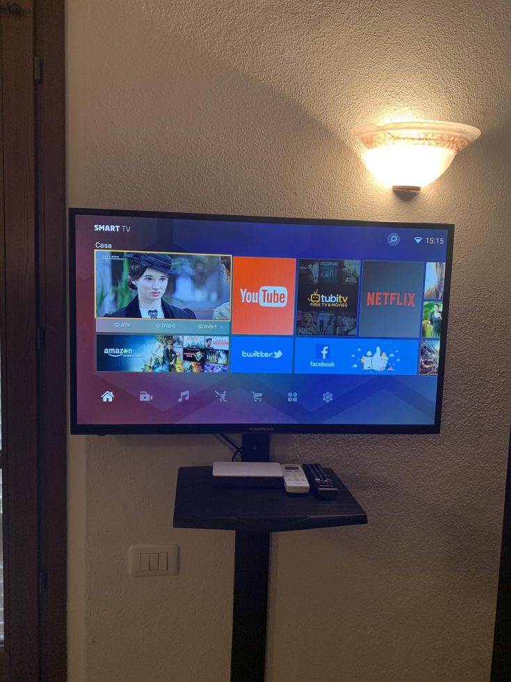 Un televisore smart dotato di varie applicazioni di streaming, situato in un contesto domestico.