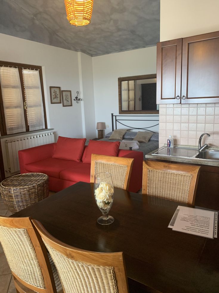 Ampio ambiente con cucina e soggiorno, arredato in modo semplice e funzionale.