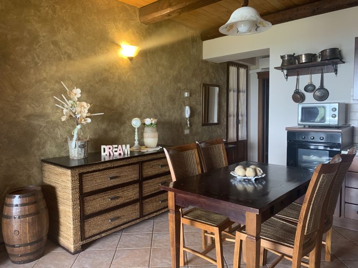 Interno semplice di un agriturismo, con tavolo in legno e decorazioni sobrie.
