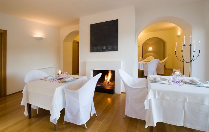 Un ristorante con camino acceso che crea un'atmosfera accogliente e riservata, perfetto per momenti di convivialità.