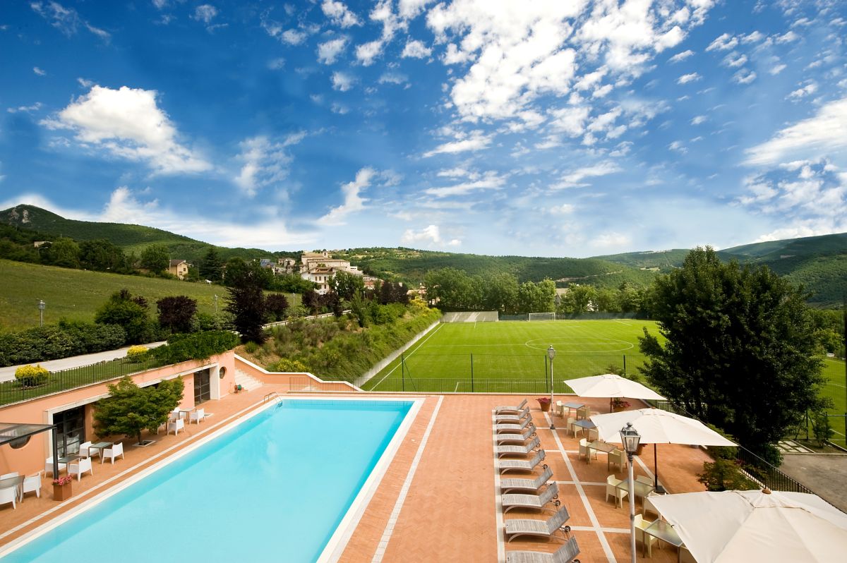 Un palazzo immerso in un vasto giardino, caratterizzato da una piscina, un campo da calcio e spazi per il relax.
