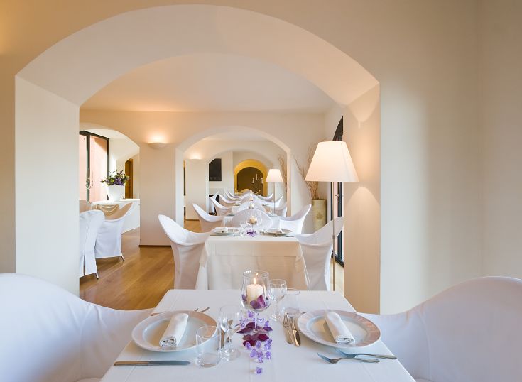 Un ristorante dal design semplice, con tavoli ben disposti e illuminazione morbida che crea un ambiente confortevole.