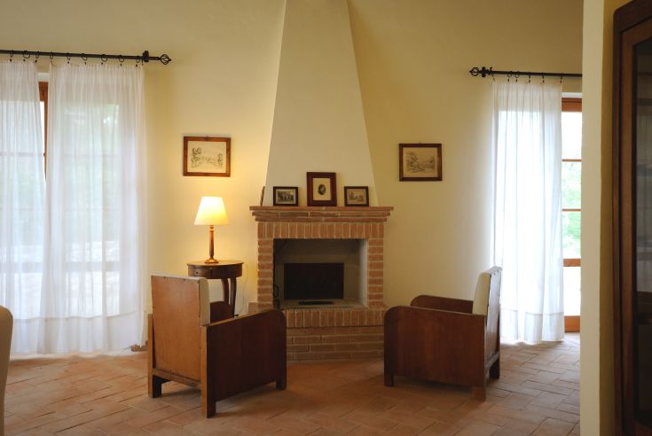 Ambiente caldo con camino, arredato in modo classico, perfetto per momenti di tranquillità.