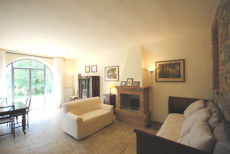 Spazio accogliente con mobili in stile classico e affaccio luminoso su un giardino.