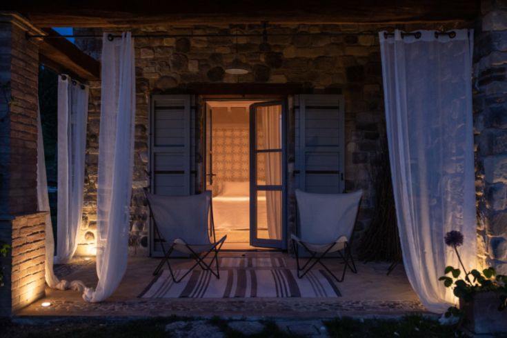 Une terrasse lumineuse avec des chaises disposées simplement, créant une ambiance sereine et décontractée.