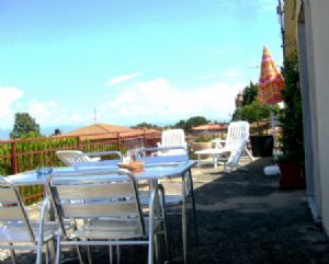 Eine mondbeschienene Terrasse mit Tischen und Stühlen, perfekt zum Entspannen und Geselligkeit.