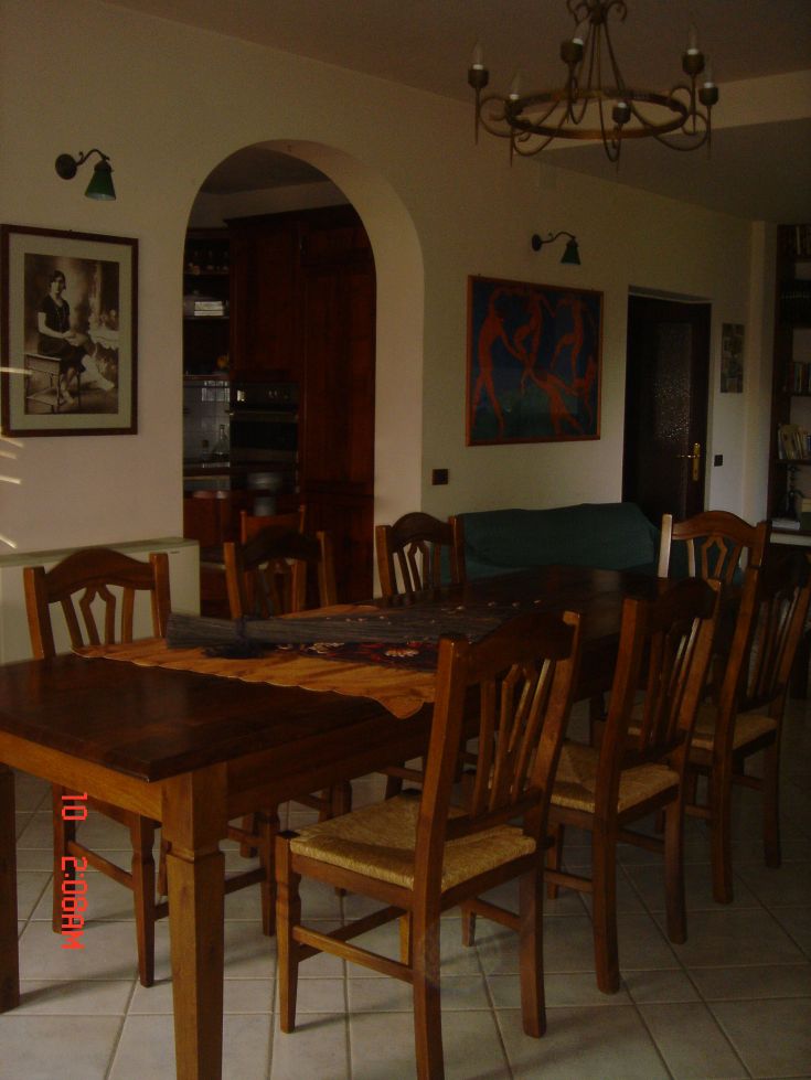 Espace repas lumineux avec une table en bois et des chaises, baigné de lumière naturelle et de détails simples.