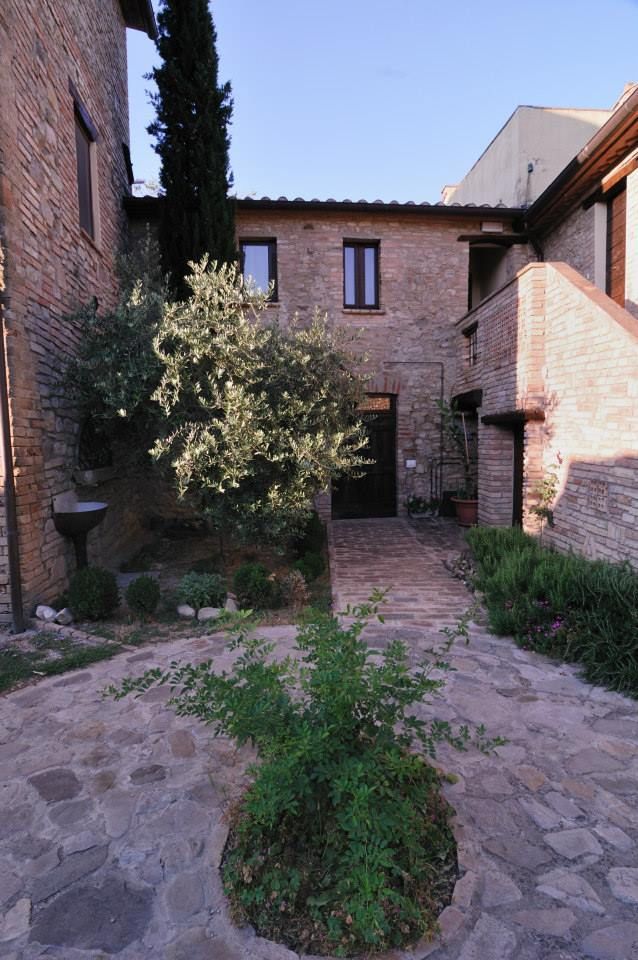 Ein Innenhof eines Bauernhofs, umgeben von Pflanzen und Steinstrukturen.