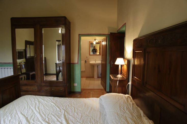 Einfache Zimmer mit Holzmobiliar und eigenem Bad, in einer natürlichen Umgebung in Umbrien gelegen.