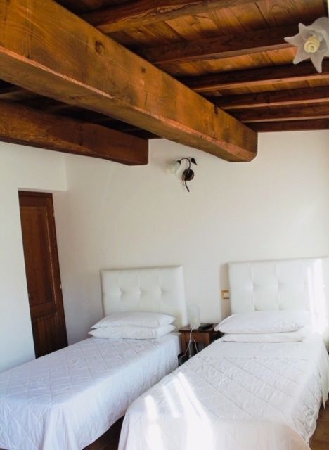 Stanza semplice con due letti singoli, adatta per un soggiorno tranquillo in agriturismo.