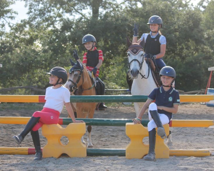 Attività a cavallo con amici nel maneggio, caratterizzata da un'atmosfera rilassata e naturale.