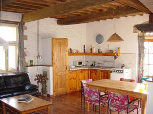 Interno di una cucina semplice con tavolo in legno e mobili chiari.