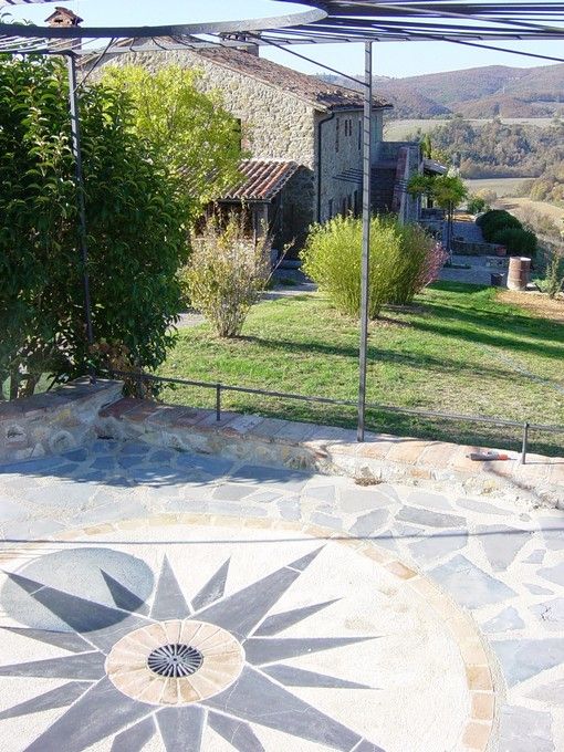 Un'abitazione in pietra situata tra la vegetazione, circondata da un giardino ben curato.