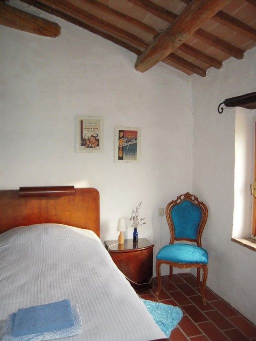 Una camera da letto semplice con mobili in legno e dettagli decorativi. Gli elementi creano un ambiente rilassante.