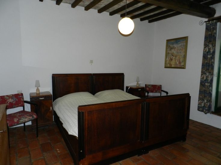 Camera semplice con un letto matrimoniale e mobili in stile tradizionale.