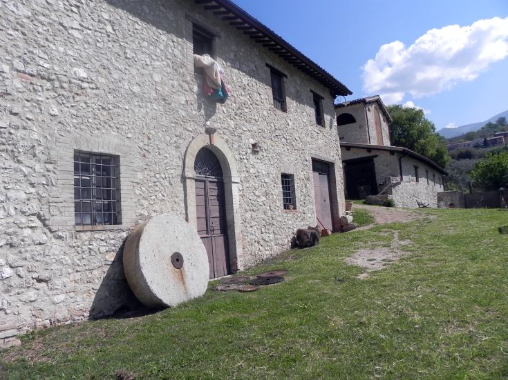 Agriturismo with stone walls and a large well-maintained garden.