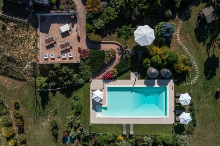 Swimming pool surrounded by a well-maintained garden, perfect for relaxing in nature.