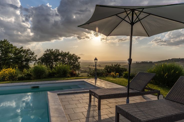 Moments of relaxation by the pool with a view of the Umbrian countryside at sunset.