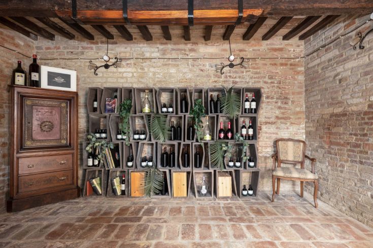 A cozy space with wooden shelves displaying wines, perfect for tasting moments.
