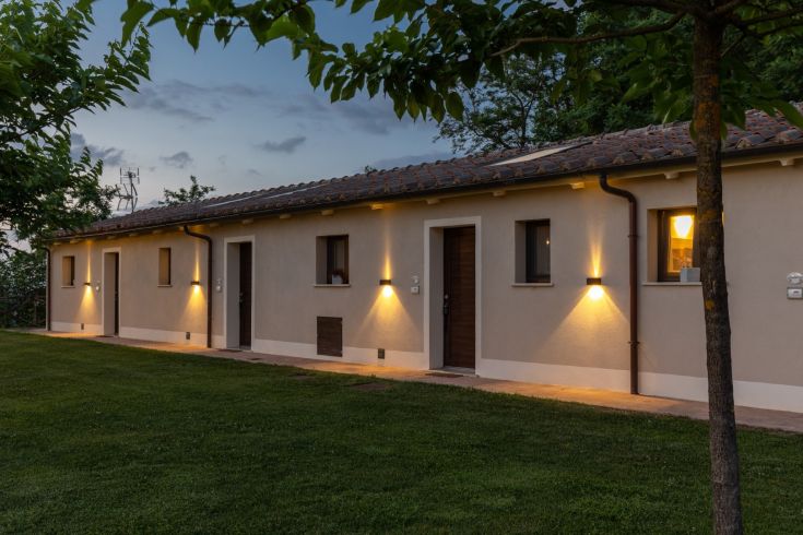 A serene farmhouse surrounded by lush greenery, perfect for a relaxing getaway.