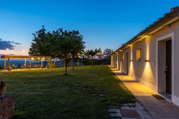 A cozy scene of Agriturismo Santa Margherita nestled in the Umbrian countryside at dusk.