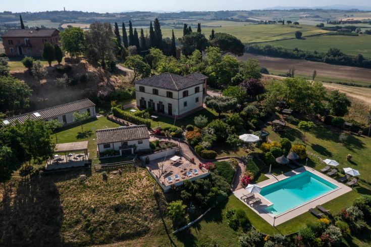 A farmhouse in the Umbrian countryside, featuring a pool and well-maintained gardens.