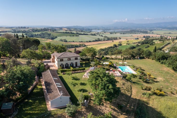 Farmhouse located in the Umbrian countryside, featuring a pool and large green areas.