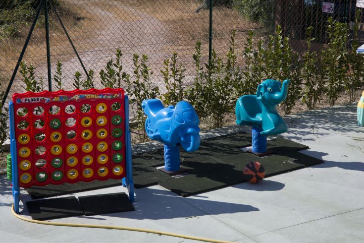 Aire de jeux pour enfants avec table interactive et deux structures à ressort en plein air.