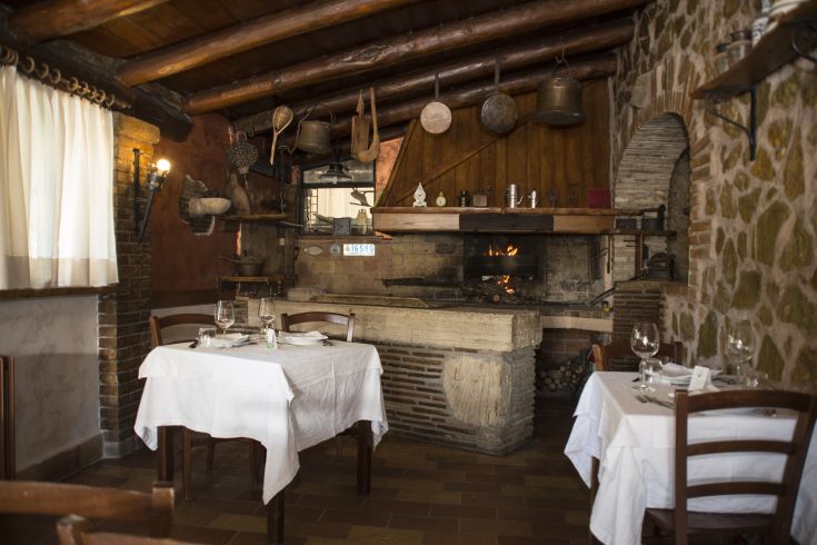 Restaurant rustique avec une cheminée et une décoration chaleureuse, parfait pour des dîners dans une ambiance conviviale.