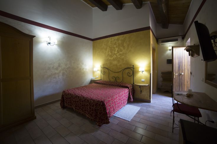 Espace simple de style rustique, aménagé avec un lit double et des éléments en bois.