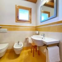 Ein geräumiges und gut beleuchtetes Badezimmer mit modernen Sanitäranlagen und einem Fenster, das eine Aussicht auf die umliegende Landschaft bietet.