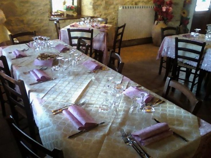 Un tavolo ben apparecchiato con tovaglia e posate, pronto per ospitare dei commensali.