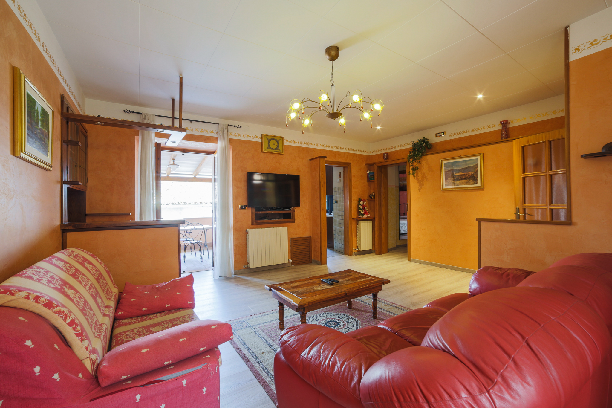 Soggiorno semplice e accogliente in un appartamento, con colori caldi e arredi pratici.