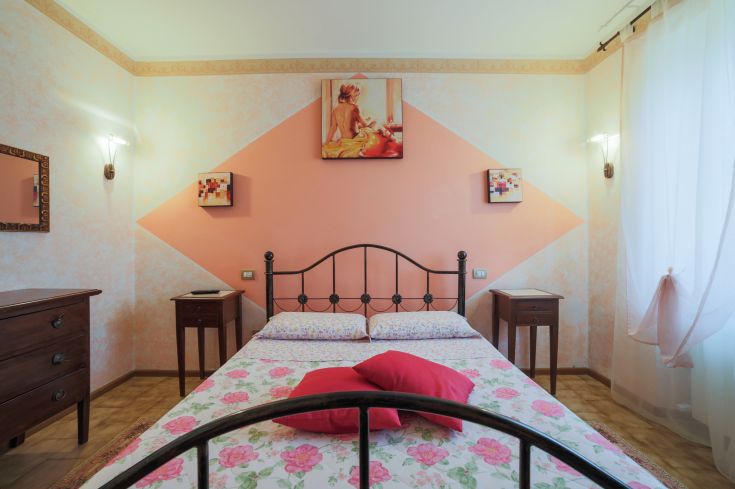 Chambre confortable avec des décorations florales et des couleurs chaudes, idéale pour des moments de détente.