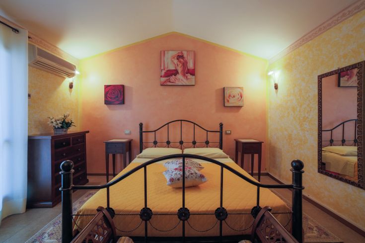 Chambre simple avec des éléments floraux et des meubles en bois, idéale pour des moments de détente.